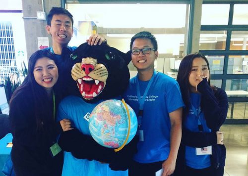 Poppie the Panther with 4 students and a globe