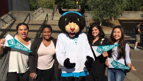 four students next to PCC's panther mascot, Poppie