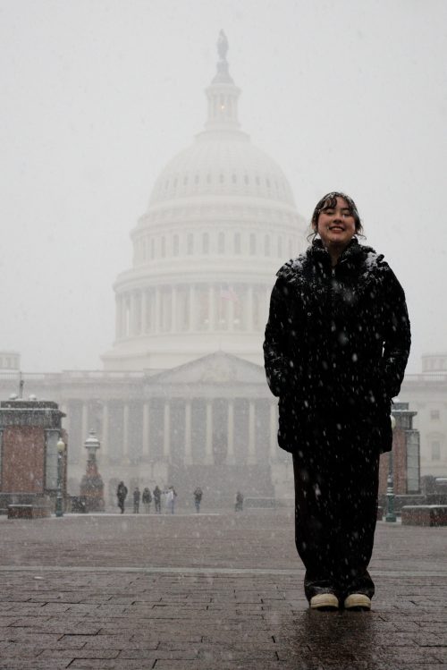 Student leader standing in front of the Oregon capital building in Salem with snow falling all around