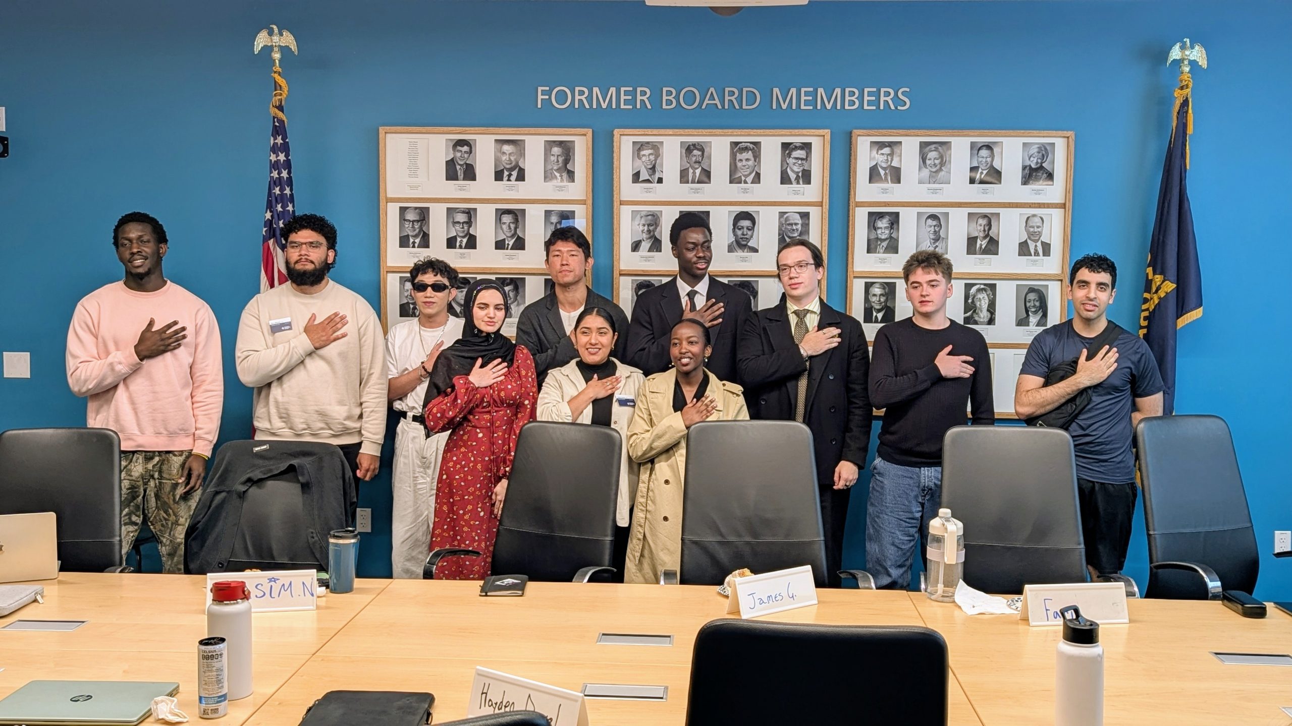 A group of student councilors standing in a meeting room, being sworn into office.