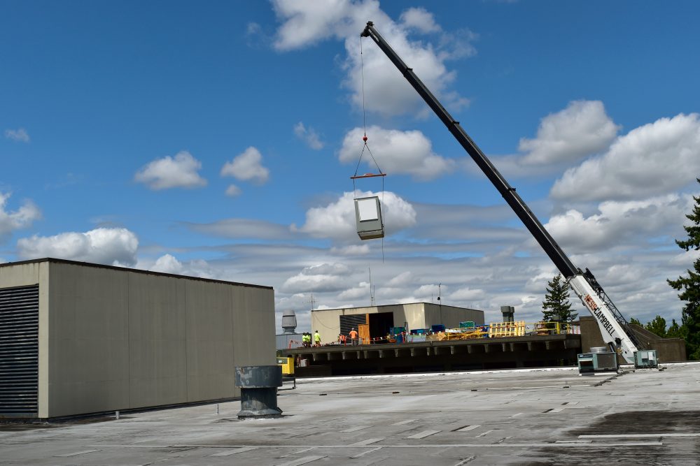 New Air Handler Unit brought up by a crane to the roof of ST building