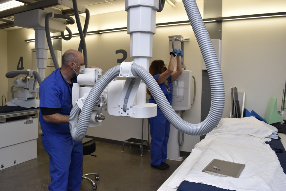 Two students using the equipment and practicing how to take x-rays