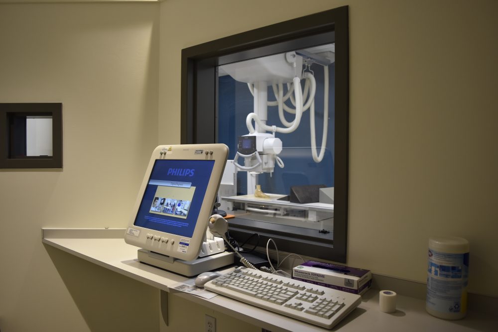 Monitor and keyboard protected by glass looking over the x-ray equiment