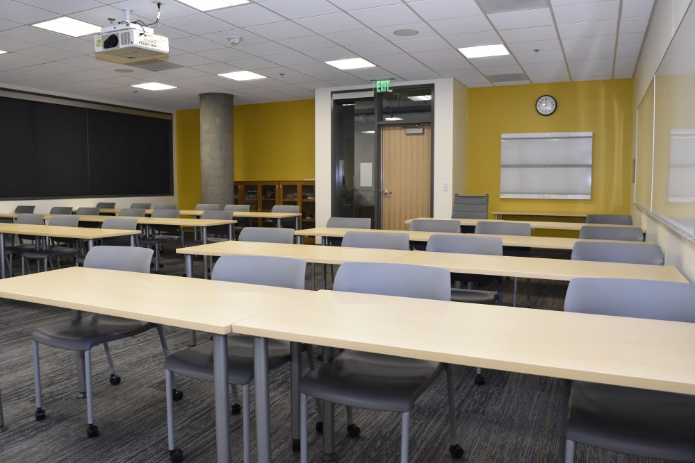 Classroom at the basement with tables lined up and chairs ready for lecture