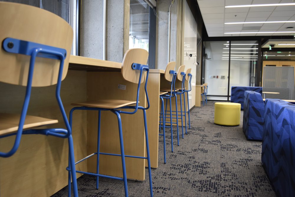 Line of high chairs on a bar facing the window and other soft seating on a carpeted area