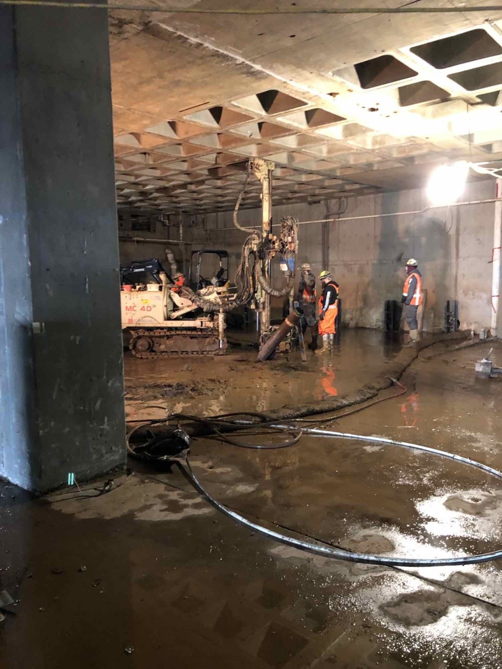 Workers at the basement of HT working with machinery that is perforating the slab