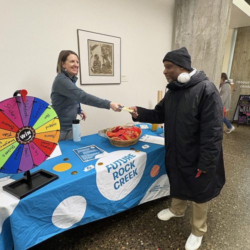 Staff member talking to a community member at an engagement event