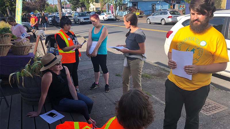 Volunteers holding surveys and talking to people on the sidewalk