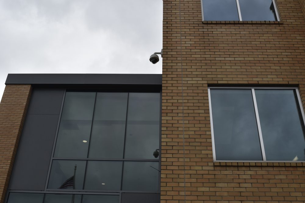 Exterior security camera at the entry of Cascade Student Union Building reflected on the window