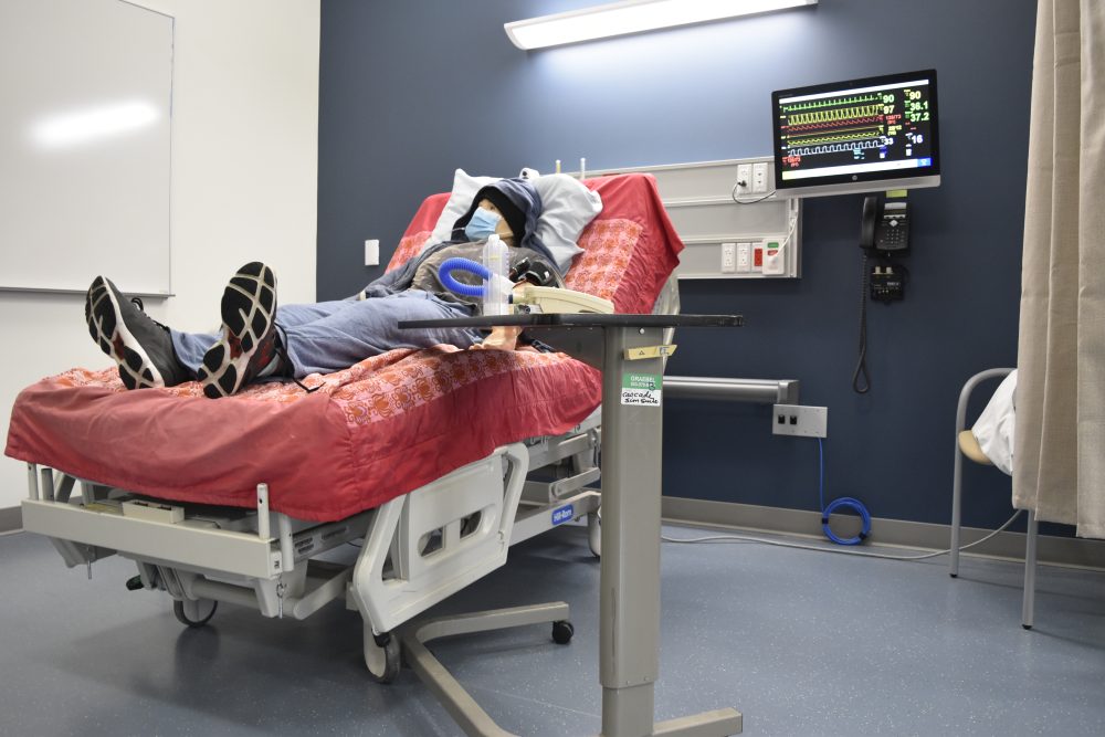 Patient room at the SIM lab with a hospital bed, vitals equipment connected to a monitor and a smart mannequin as patient