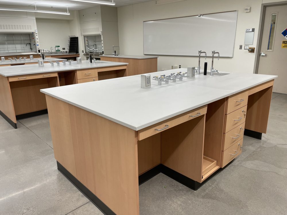 Lab station that accommodates four students, whiteboard on the back of the room