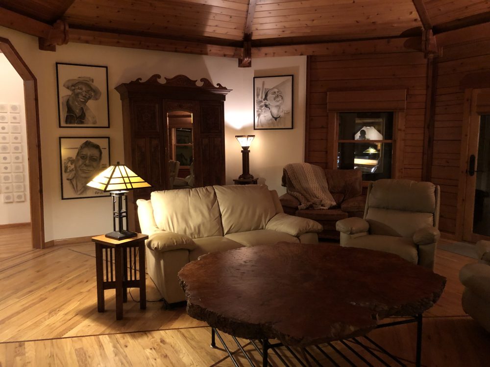 Main room soft seating and ample coffee table showing art on the walls