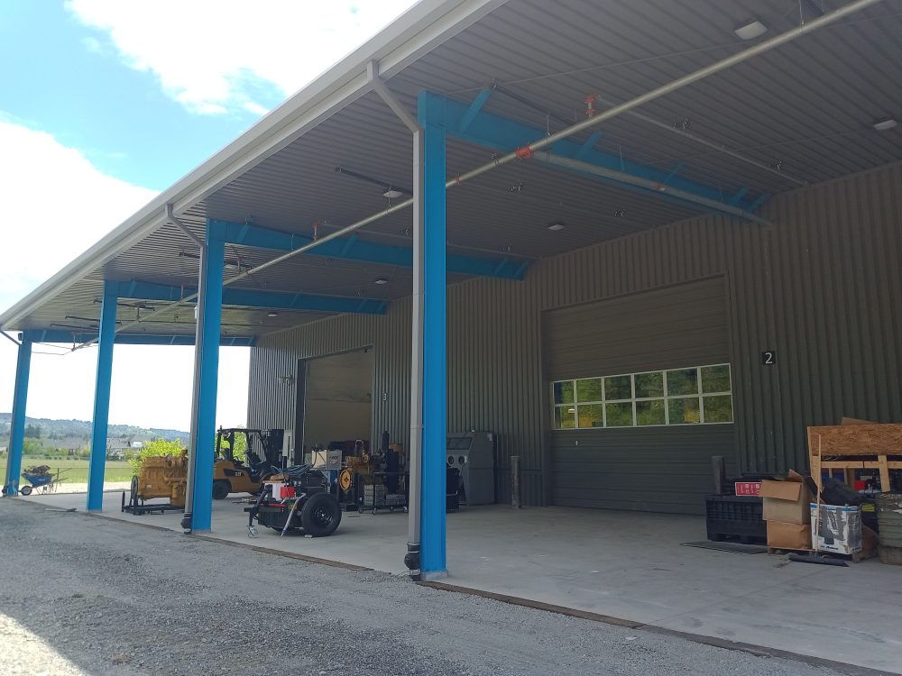 Exterior covered bay on the back of building to allow students to work on engines outdoors