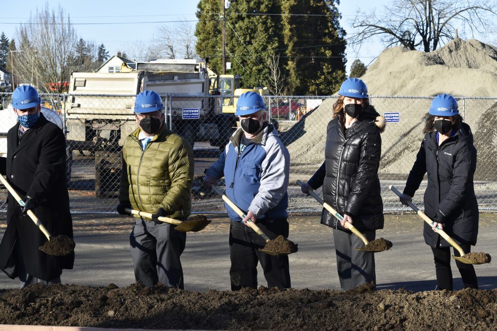 Leaders with shovels, lifting dirt to mark the project groundbreaking