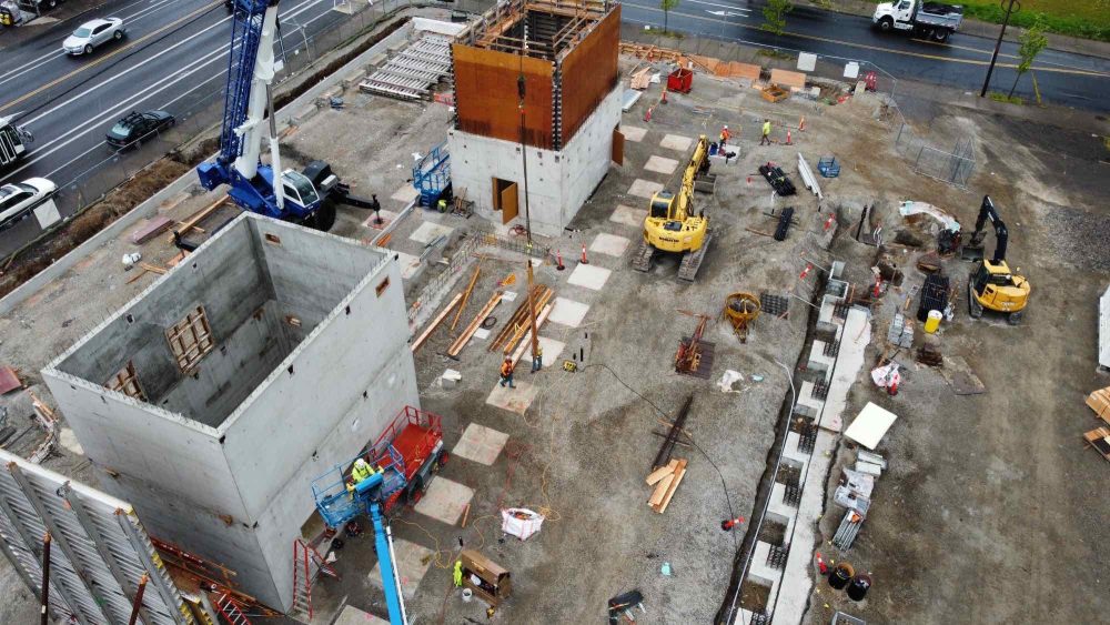 Aerial view aiming SW, looking at footings and worker on the crane