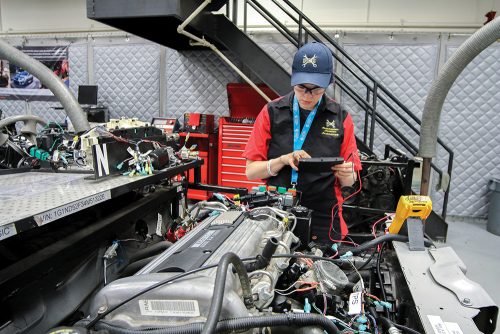 Student working on a car in the automotive service garage