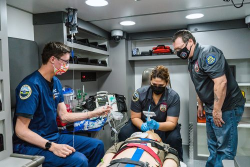 Emergency medical services (EMS) students in an ambulance with a medical dummy