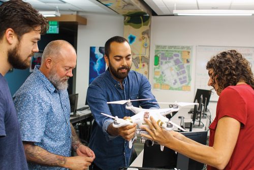 Geographic information systems (GIS) students working with a drone