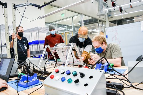 Mecatronics students working with an instructor in a lab