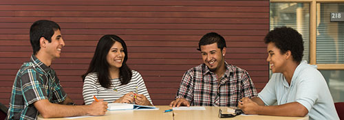 students and staff around table