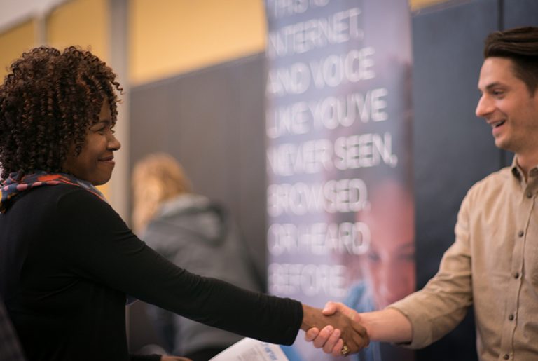 Student and recruiter shake hands at the Cascade job fair