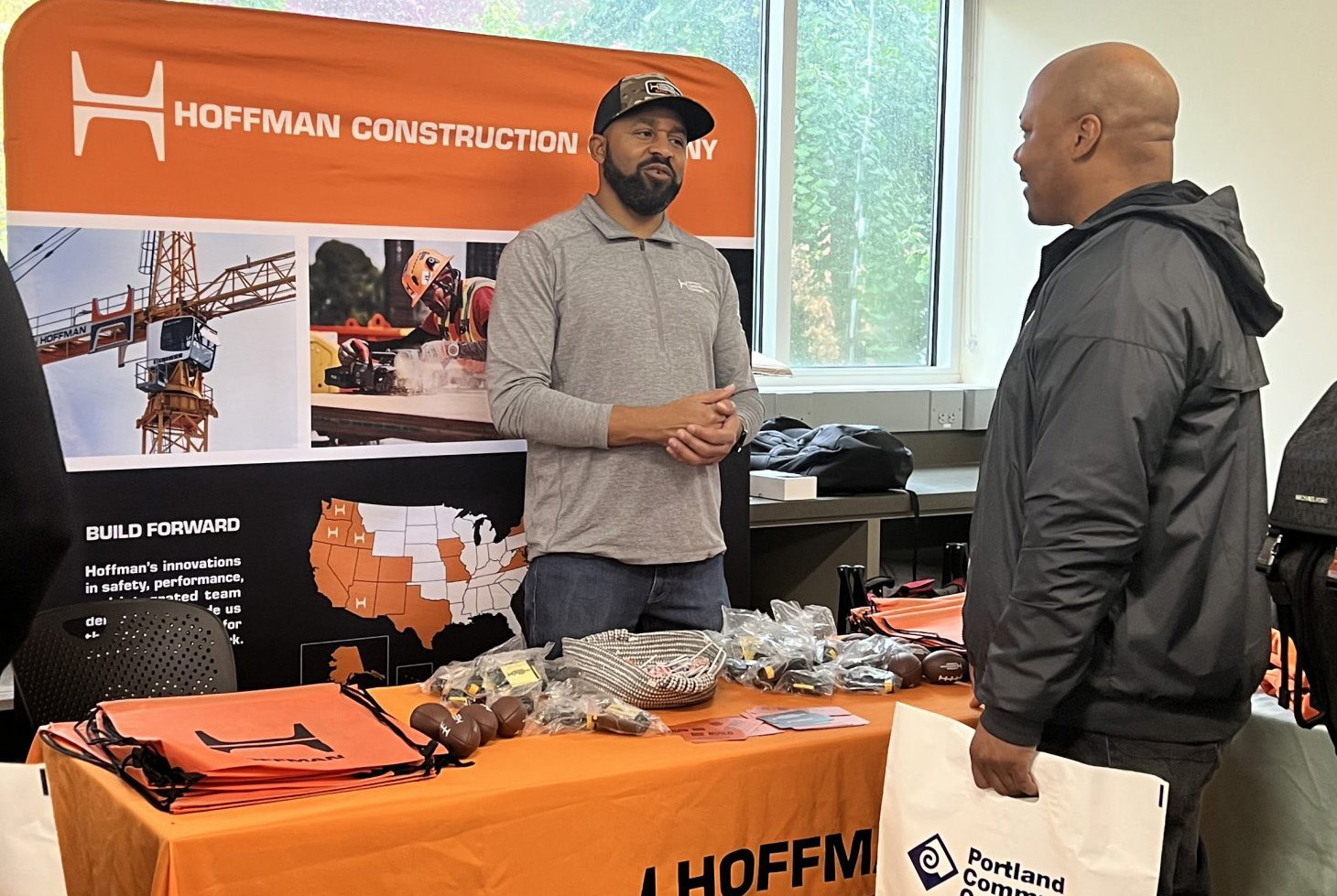 Construction company table at job fair with recruiter and PCC student in conversation