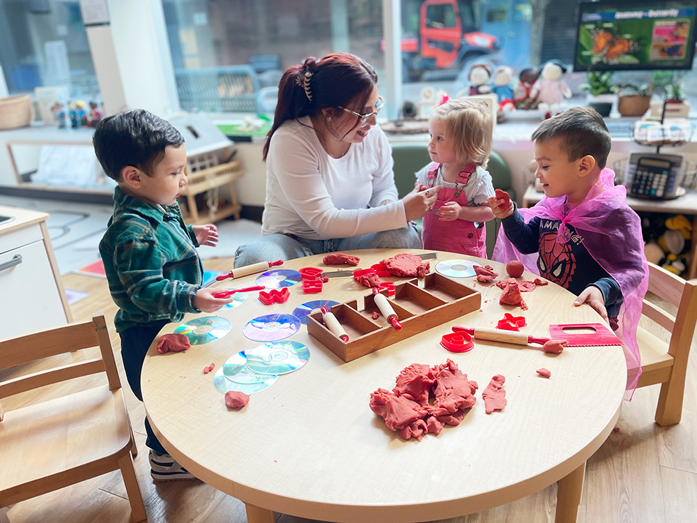 Teacher doing crafts with children at a table