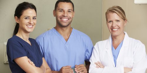 Portrait Of Dentist And Dental Nurses In Surgery garb