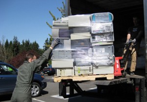 Old computer parts being loaded into a truck to be recycled.