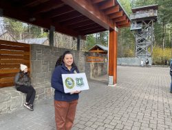 Tillamook Forest employee Alejandra Arrellano greets the PCC students outside of the Forest Center. She holds a sign with the seals of the two organizations that govern the forest – the Oregon Department of Forestry and the US Forest Service. 