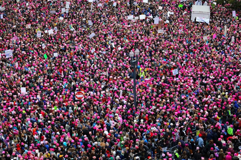 Photo of thousands of people in pink hats protesting in the streets.