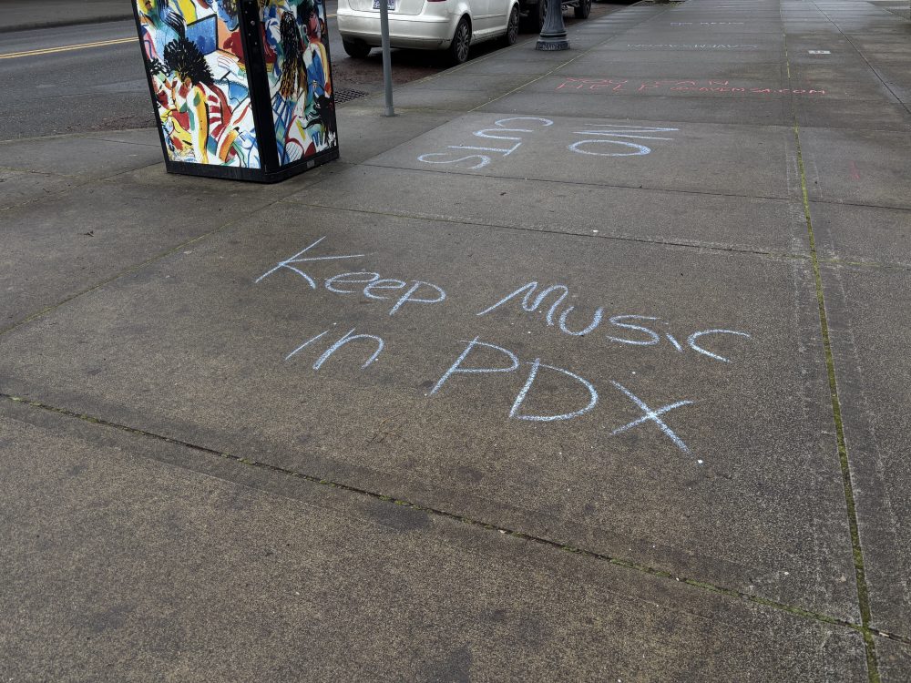 Chalk art on sidewalk that reads: "Keep Music in PDX. No Cuts."