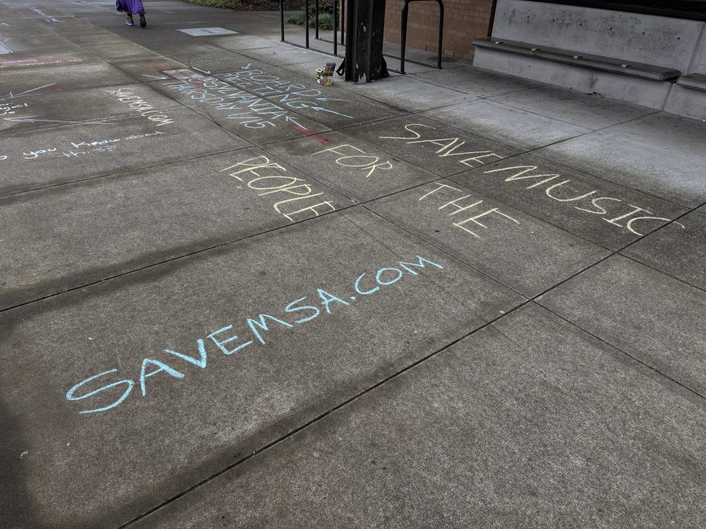 Chalk art on sidewalk that reads: "Save Music For The People. Savemsa.com."
