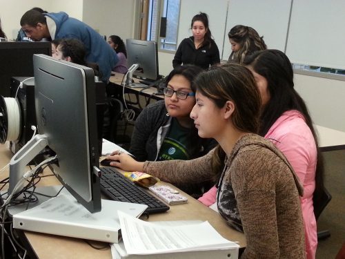 High school students in a dual credit class using a computer together