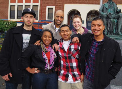 Group of diverse students standing together posing for the camera outside a local highschool