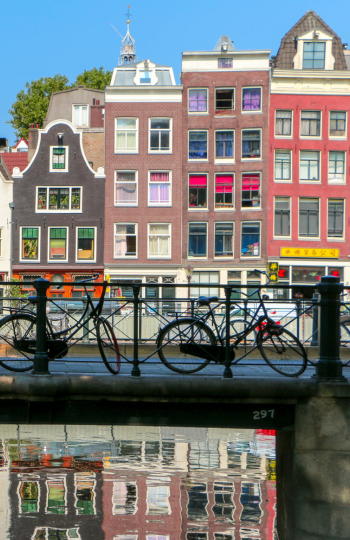 bicycles parked along a bridge next to a canal