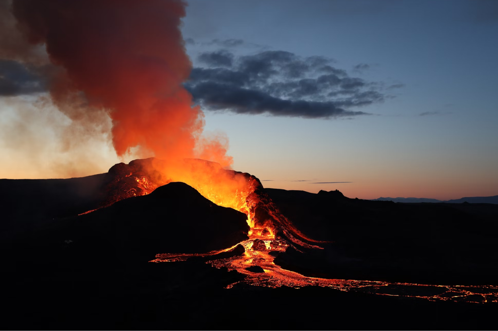 volcano erupting lava into the night sky