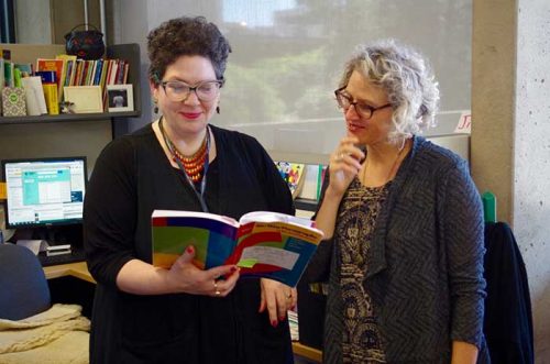 two women reading a book together