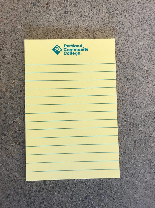 Yellow lined notepad with turquoise PCC logo at the top