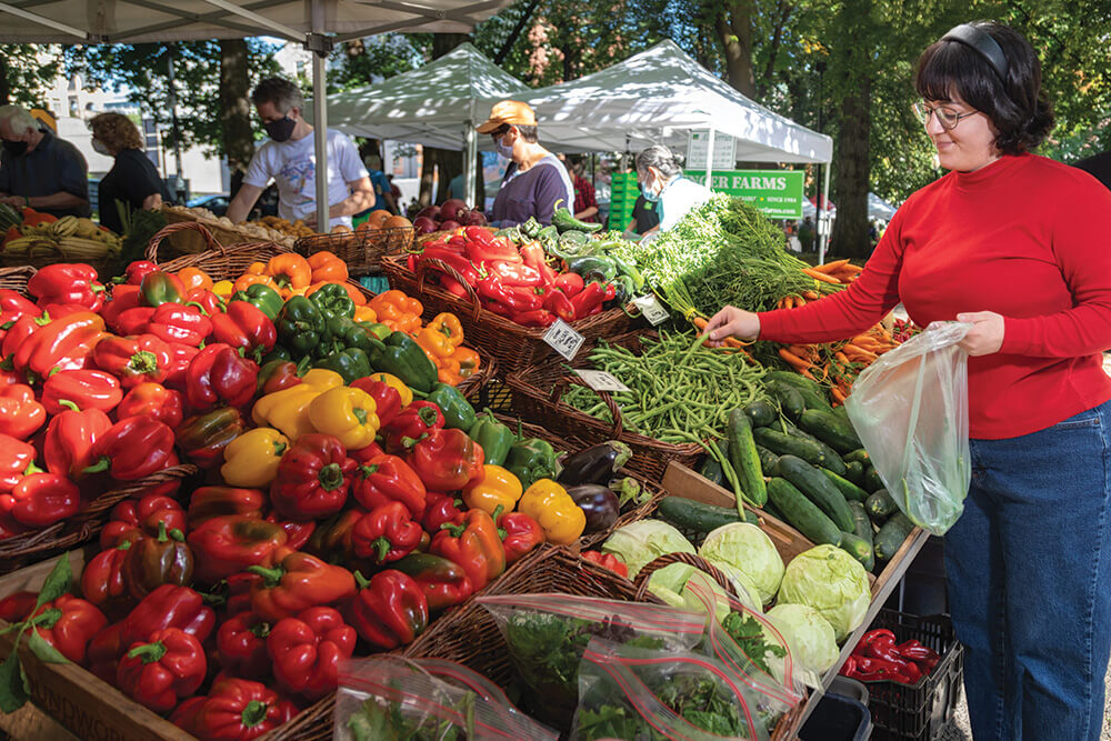 Anya picking out produce at a farmer's market