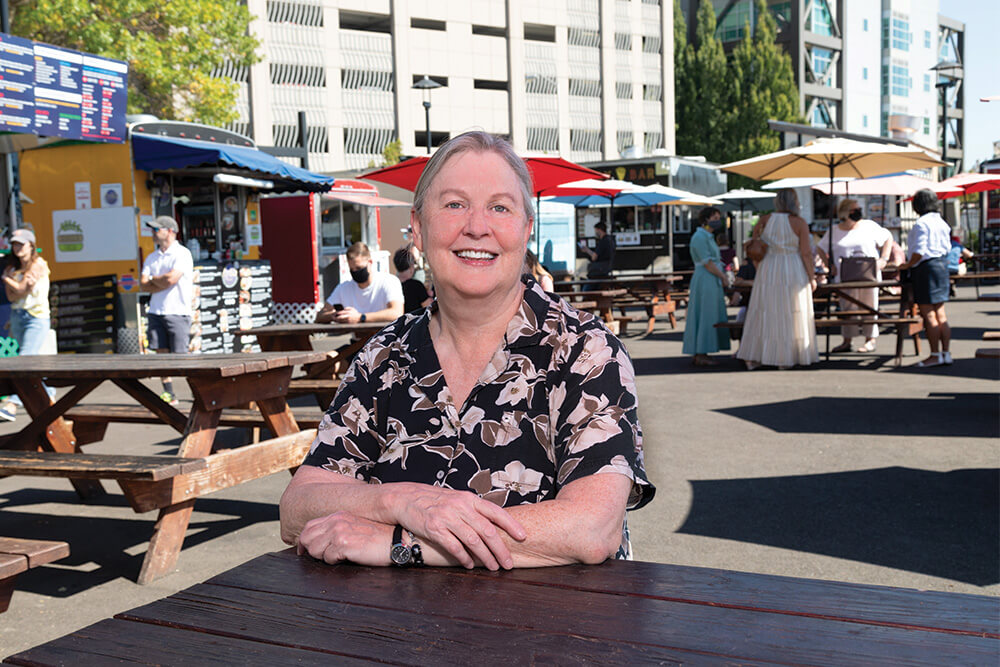 Deb sitting at a table at a food truck pod