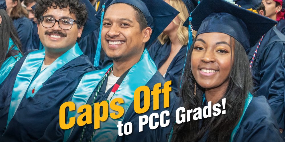A row of three smiling graduates in blue caps and gowns with the words "Caps off to PCC Grads"