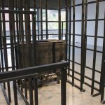 Detail view of wooden framed rectilinear sculpture, a black wooden box is in center.