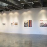 Gallery wall with five abstract, landscape paintings ranging in size from 13.5 by 20 inches to 36 by 45 inches.