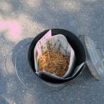 Lidded containers are prepared with combustible materials such as newspaper, pine needles, leaves, etc.