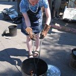 Hot glazed pieces are placed in a prepared bucket for reduction.