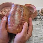 The surface is further enhanced by applying a liquid polymer coating that seals the surface and enriches many of the subtle colors achieved during the firing.