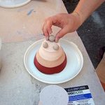 The salt introduced to the heated atmosphere inside the kiln vaporizes and adheres to every surface inside the kiln. For this reason "wads" are made of a material that will not be coated and each piece and all shelves and posts are "wadded" to prevent them from sticking to shelves.