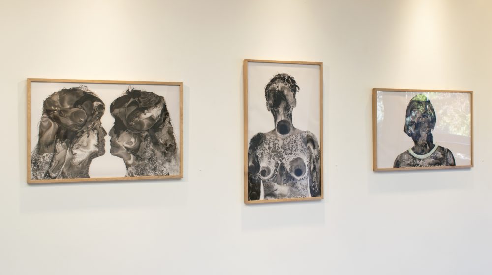 Three framed ink drawings of human figures; the ink is in shades of from black to gray and is in a loose, fluid style.