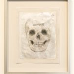 drawing of skull on paper in frame